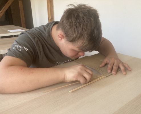 Kluci vyráběli vázičky pro maminky z kartonu a špejlí.