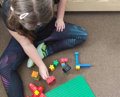 Hraní si s barevnými kostkami, stolní hra Dobble, autíčka, puzzle, Lego, prohlížení si knížek, kreslení obrázků